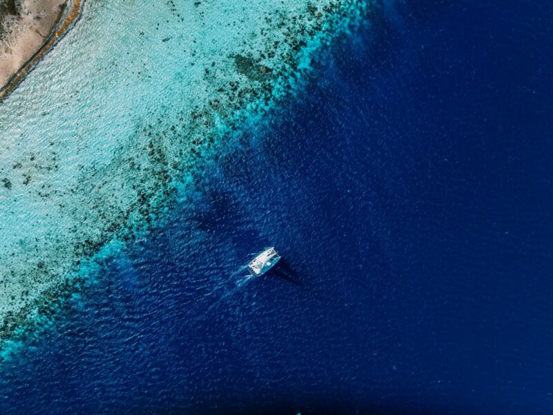 Aerial view of a private catamaran sailing over Bonaire's coral reef