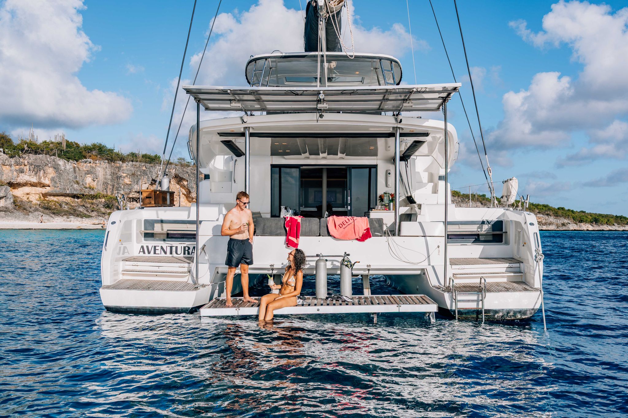 guests relaxing on the swim platform of a multi-day private catamaran charter in Bonaire
