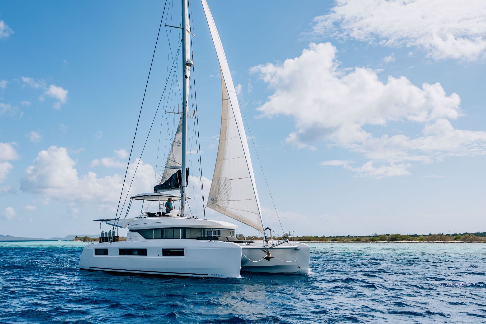 multi-day private luxury catamaran under full sail near Bonaire's coastline