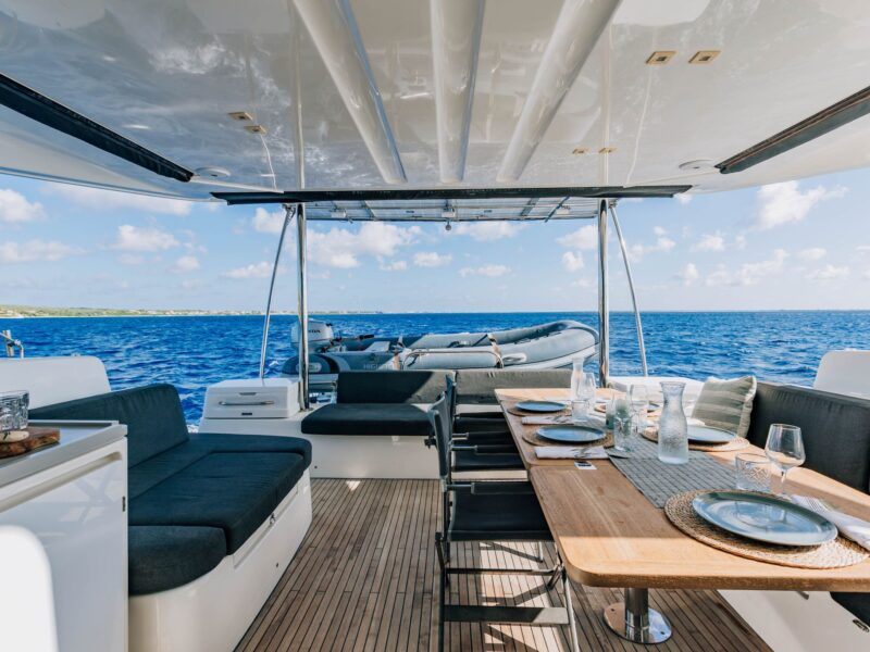 Outdoor dining table on the aft deck of a private catamaran charter
