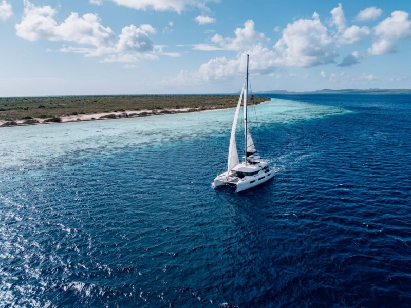 Private catamaran under sail along Bonaire's coastline and beach