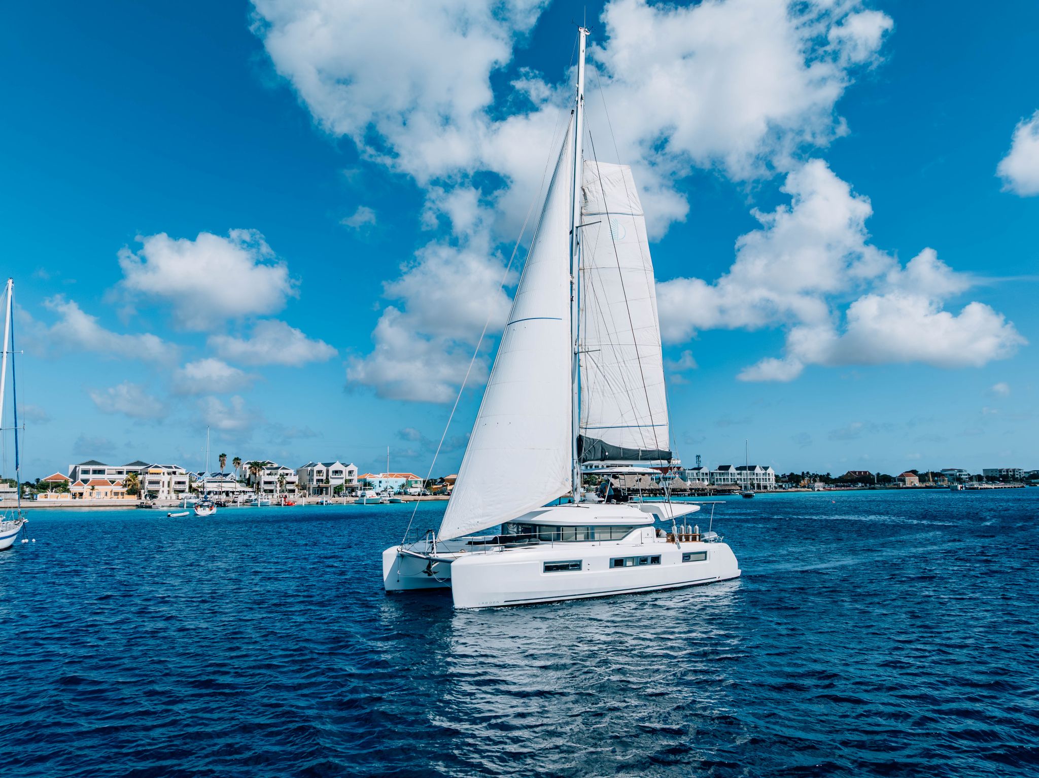 multi day private catamaran charter sailing toward Kralendijk harbor Bonaire