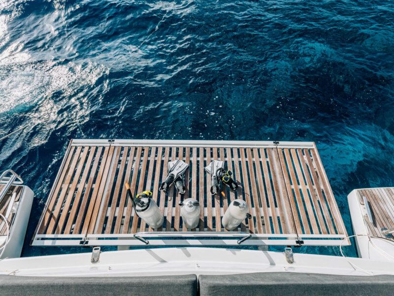 Snorkel fins and dive tanks on the swim platform of a private catamaran charter